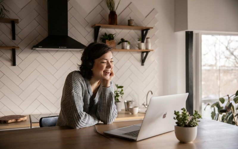 Uma mulher eficiente gerenciando sua equipe de forma remota a partir da cozinha, utilizando ferramentas online para otimizar a comunicação e a colaboração.