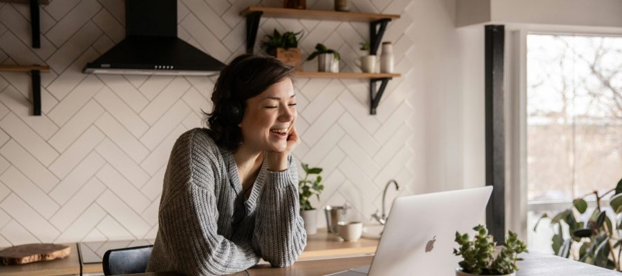 Uma mulher eficiente gerenciando sua equipe de forma remota a partir da cozinha, utilizando ferramentas online para otimizar a comunicação e a colaboração.